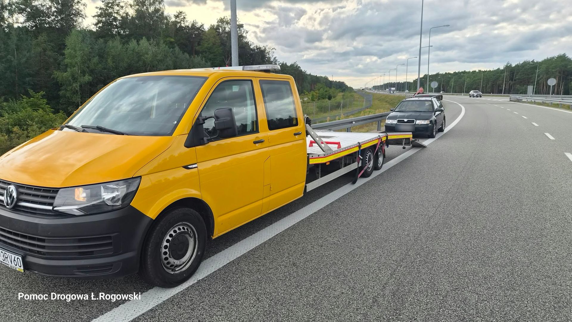 Żółta laweta przy aucie po awarii na drodze ekspresowej